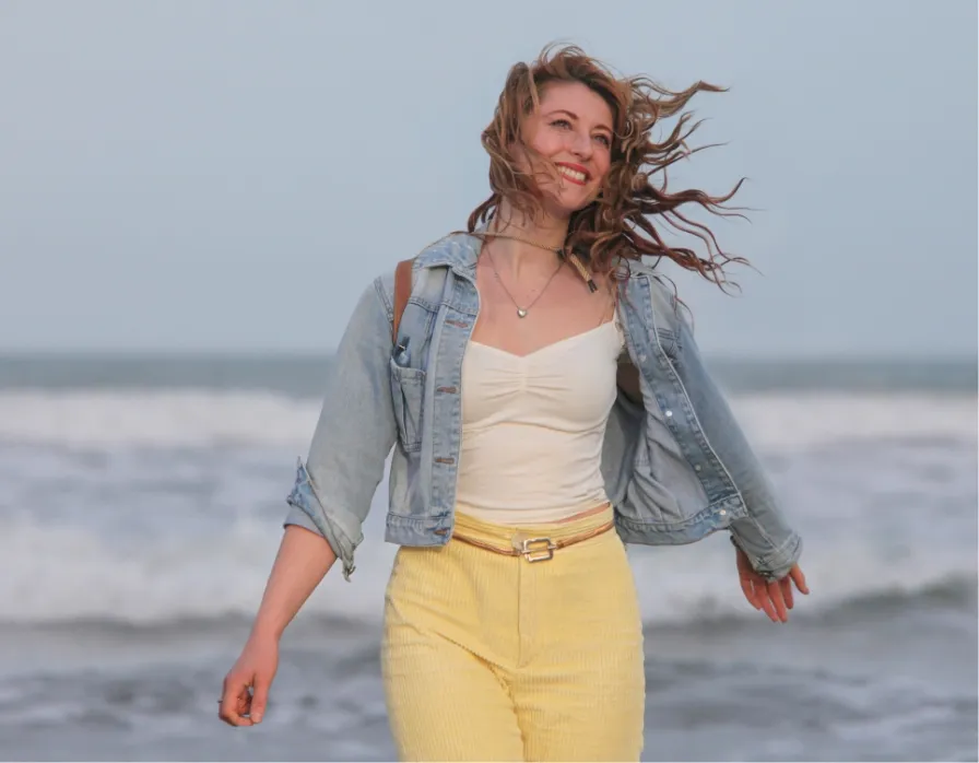 cheerful young redhead woman enjoying ocean on bea utc webp